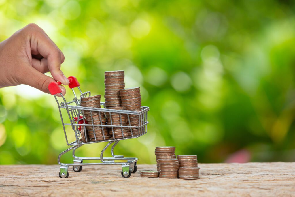 Close up picture of  a hand pushing little cart which full of coins